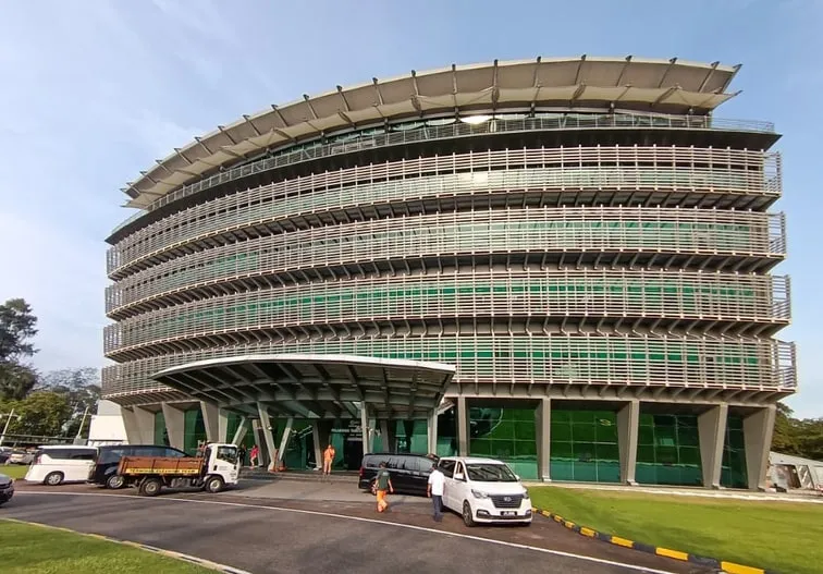 Curved louvred office block at PTP Wisma, Tanjung Pelepas, after refurbishment, in evening light